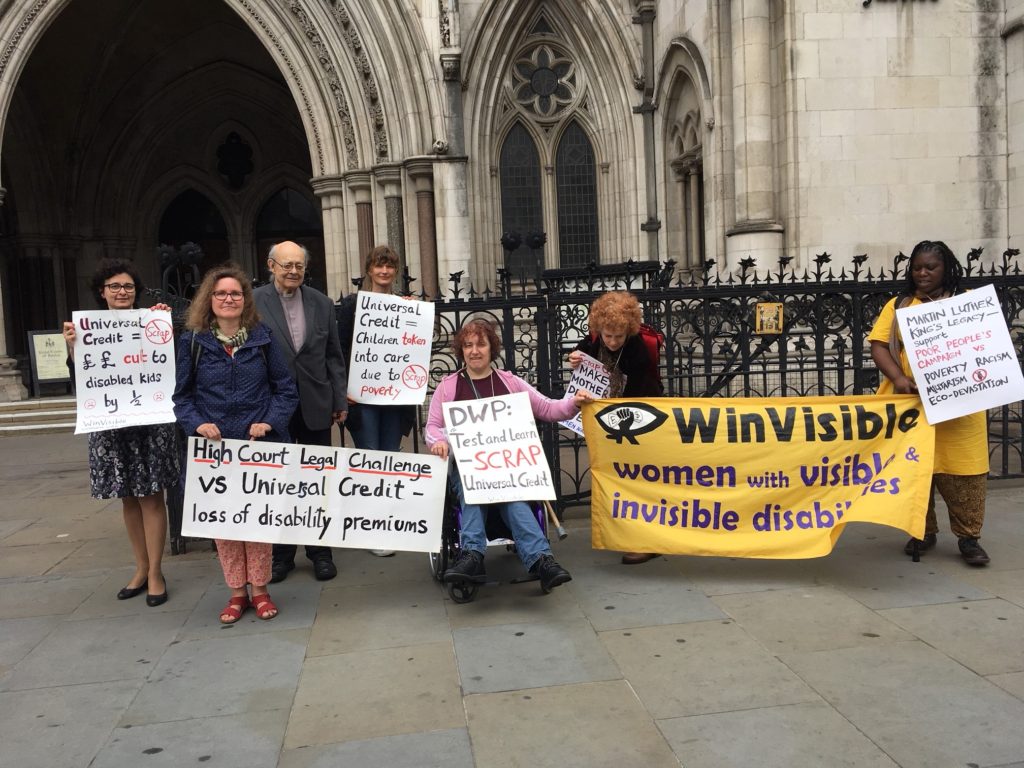 Protestors outside the high court with placards about universal credit and a large WinVisible banner