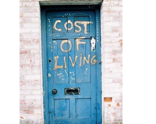 Blue door with spray painted text reading Cost of Living